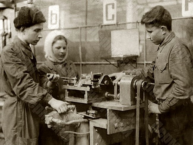 Мастер Молотовского завода №33 П.П. Зубарев (первый слева) обучает молодых рабочих завода работе на станке