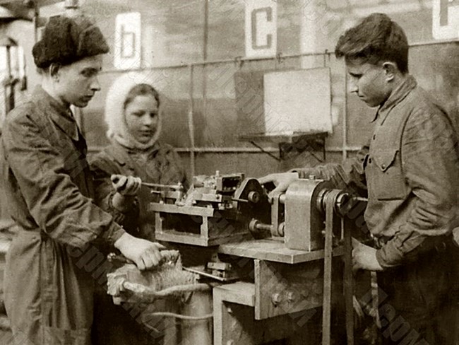The foreman of the Molotov Plant No. 33, P.P. Zubarev (first on the left), teaches young plant workers about working on a machine